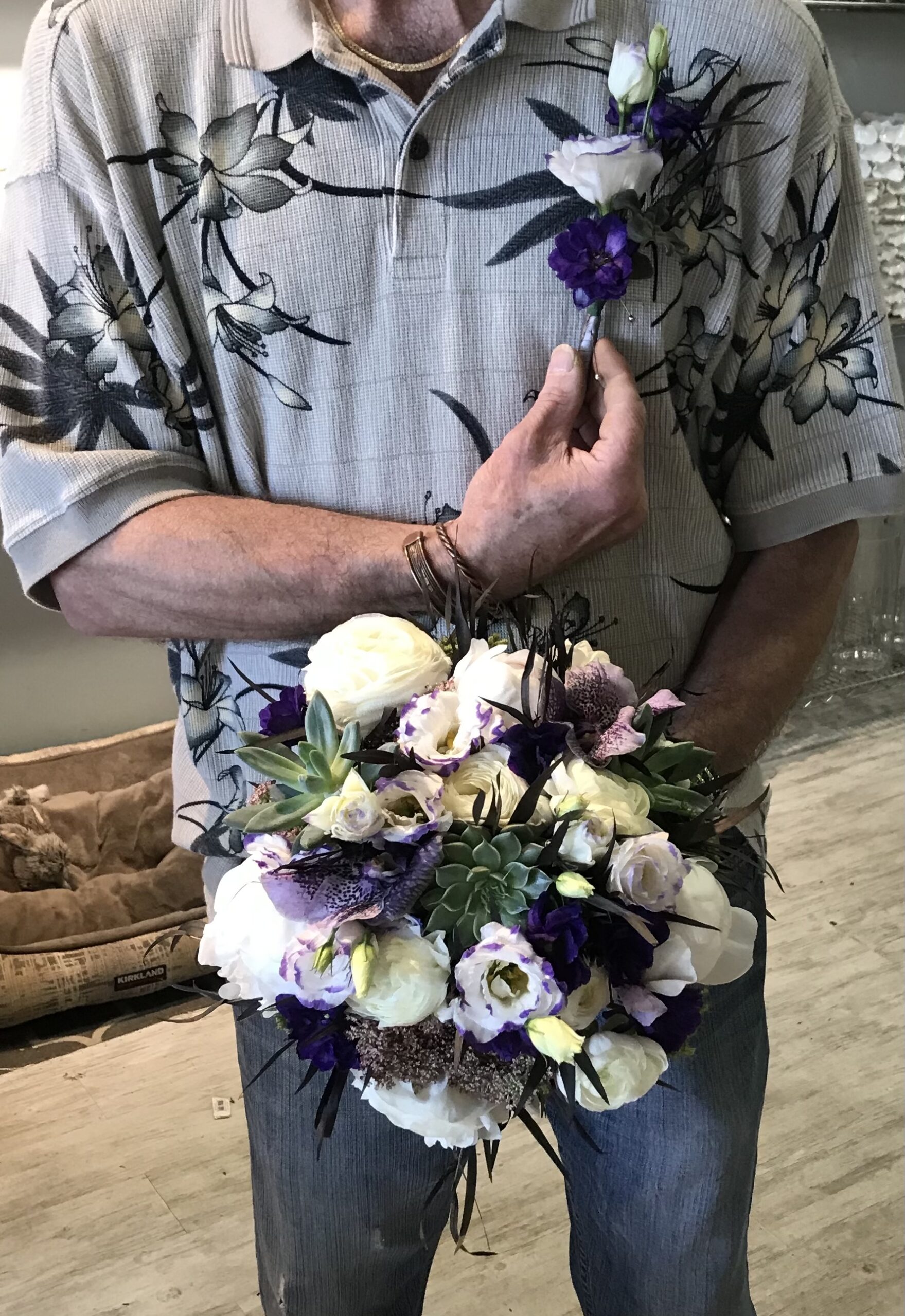 A man holding a bouquet of flowers in his hand.