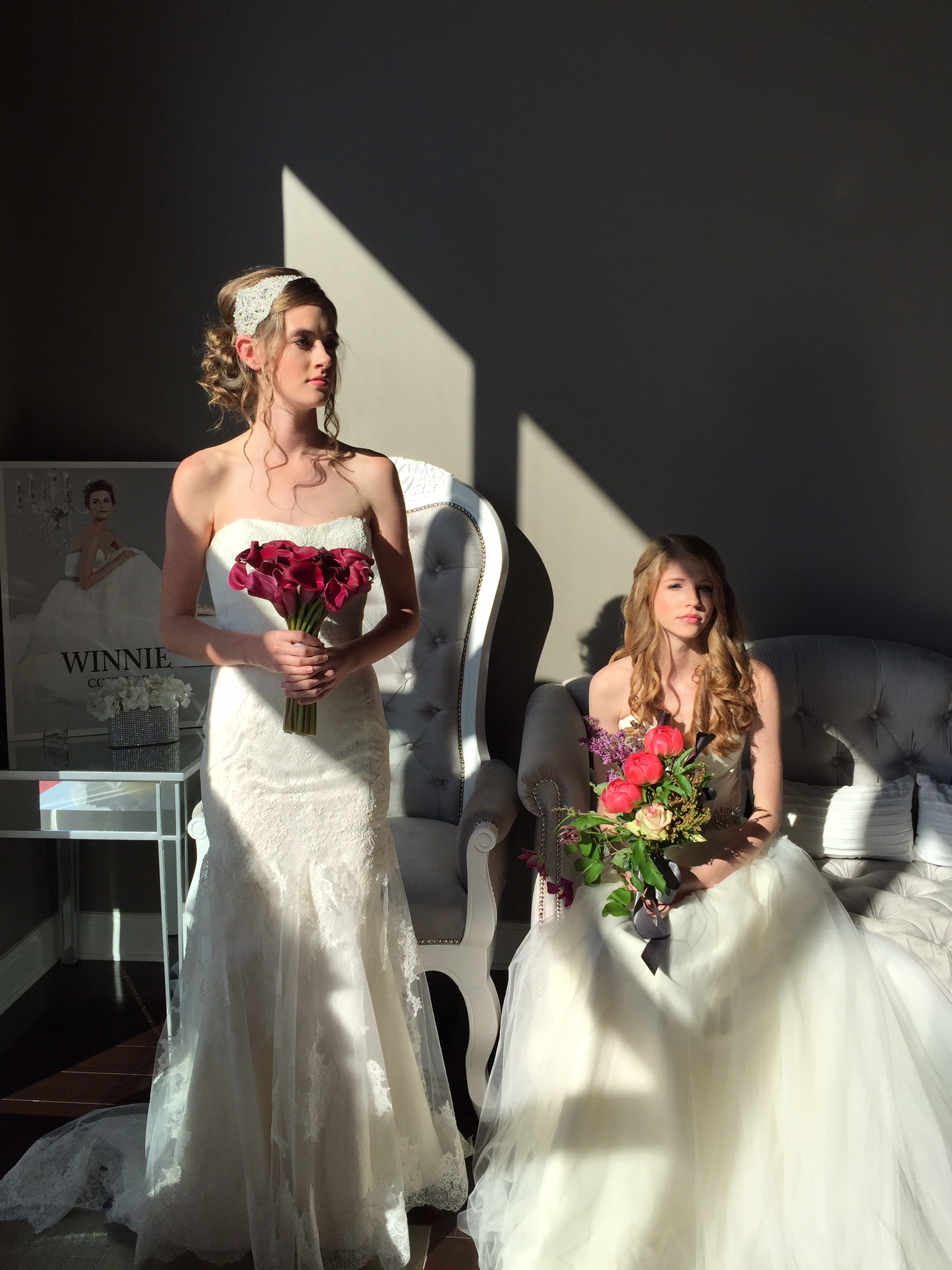Two women in wedding dresses posing for a picture.