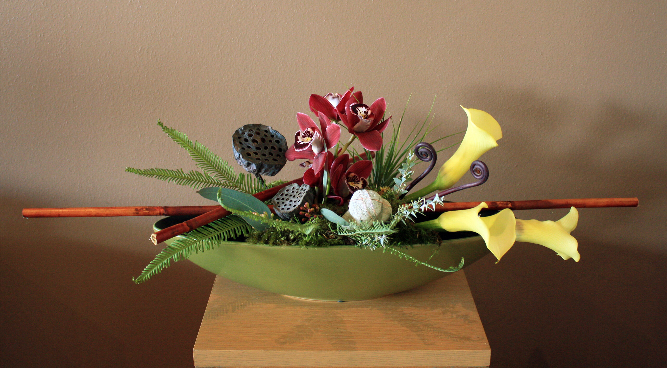 A green bowl filled with flowers on top of a table.