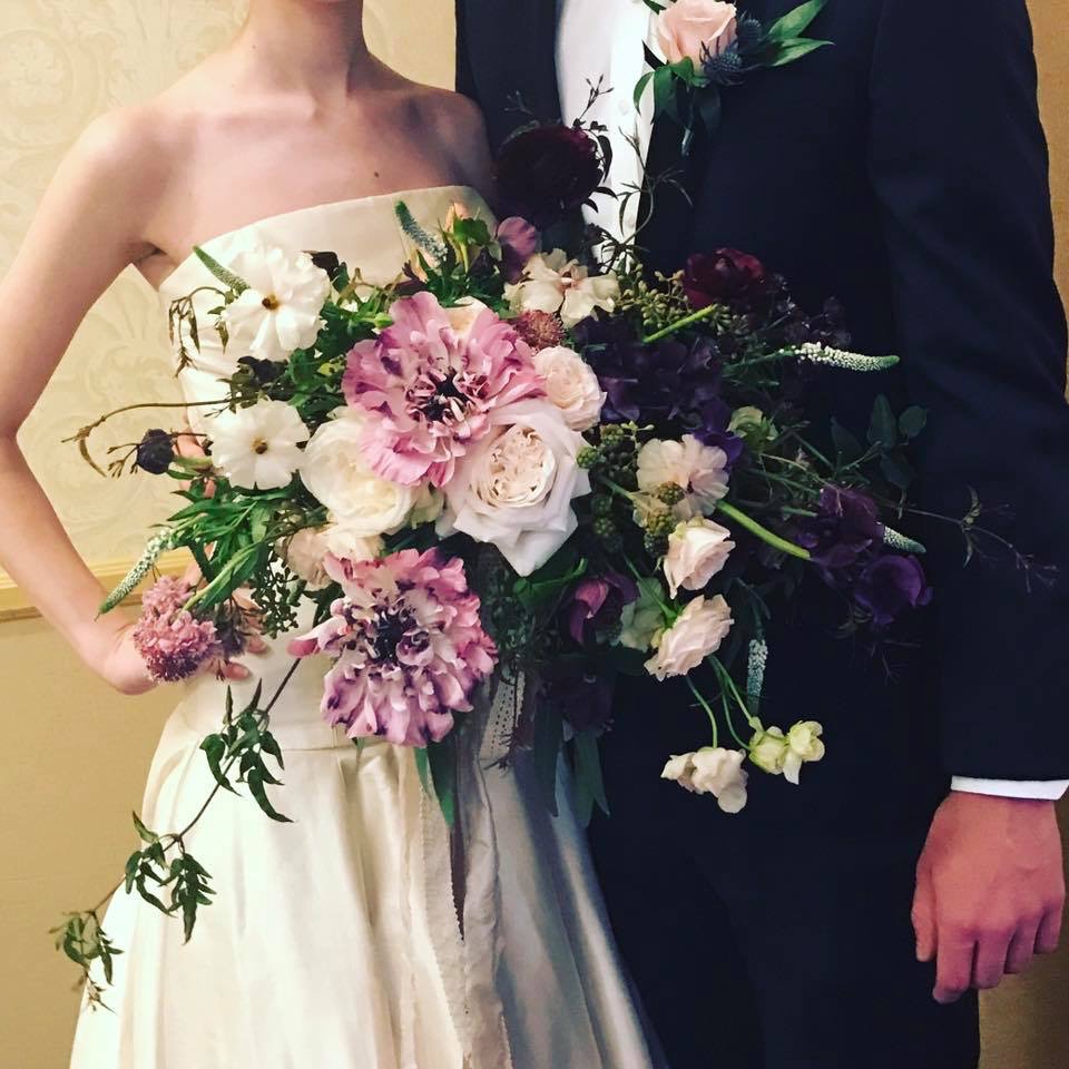 A bride and groom with their wedding bouquet.