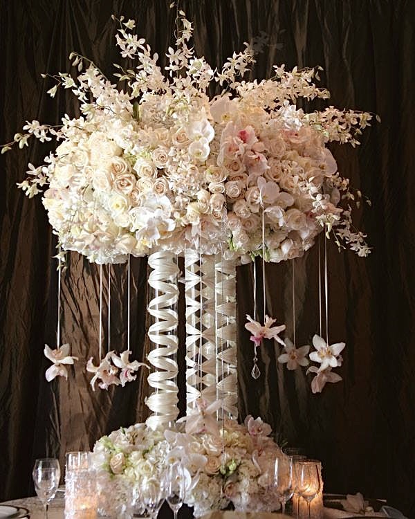 A large white floral arrangement with hanging flowers.
