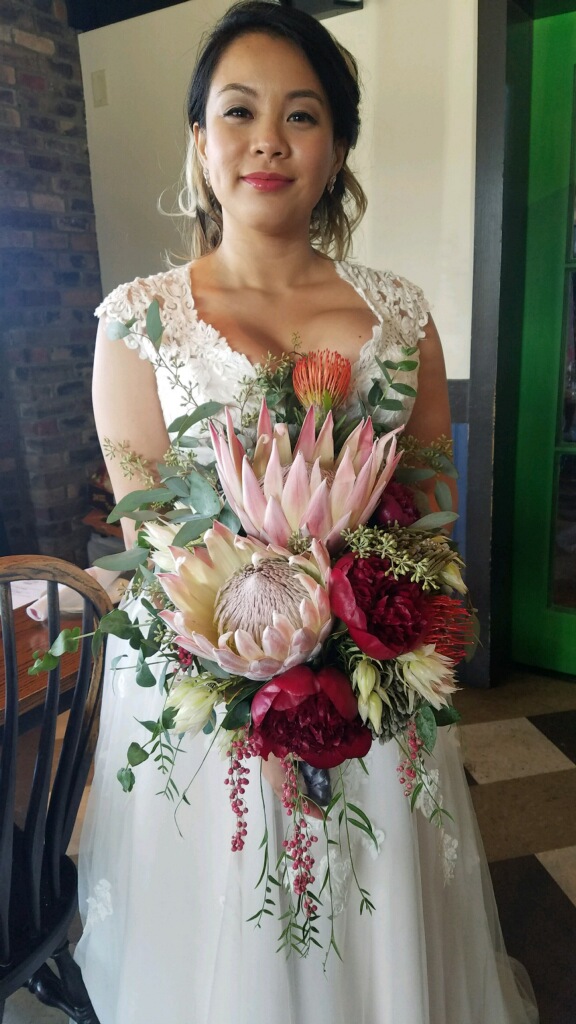 A woman in white dress holding a bouquet of flowers.