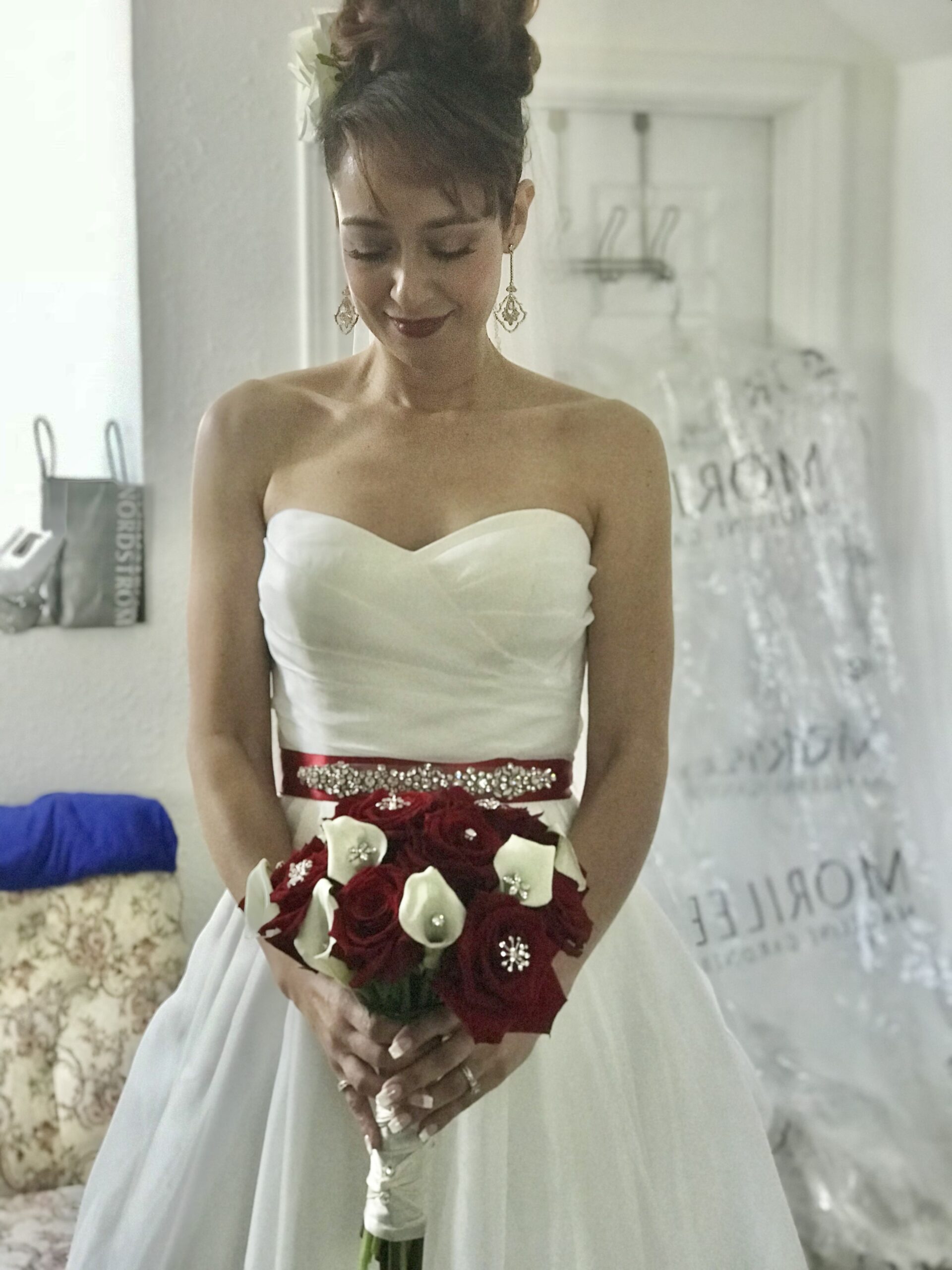 A bride holding her bouquet of flowers in front of the mirror.