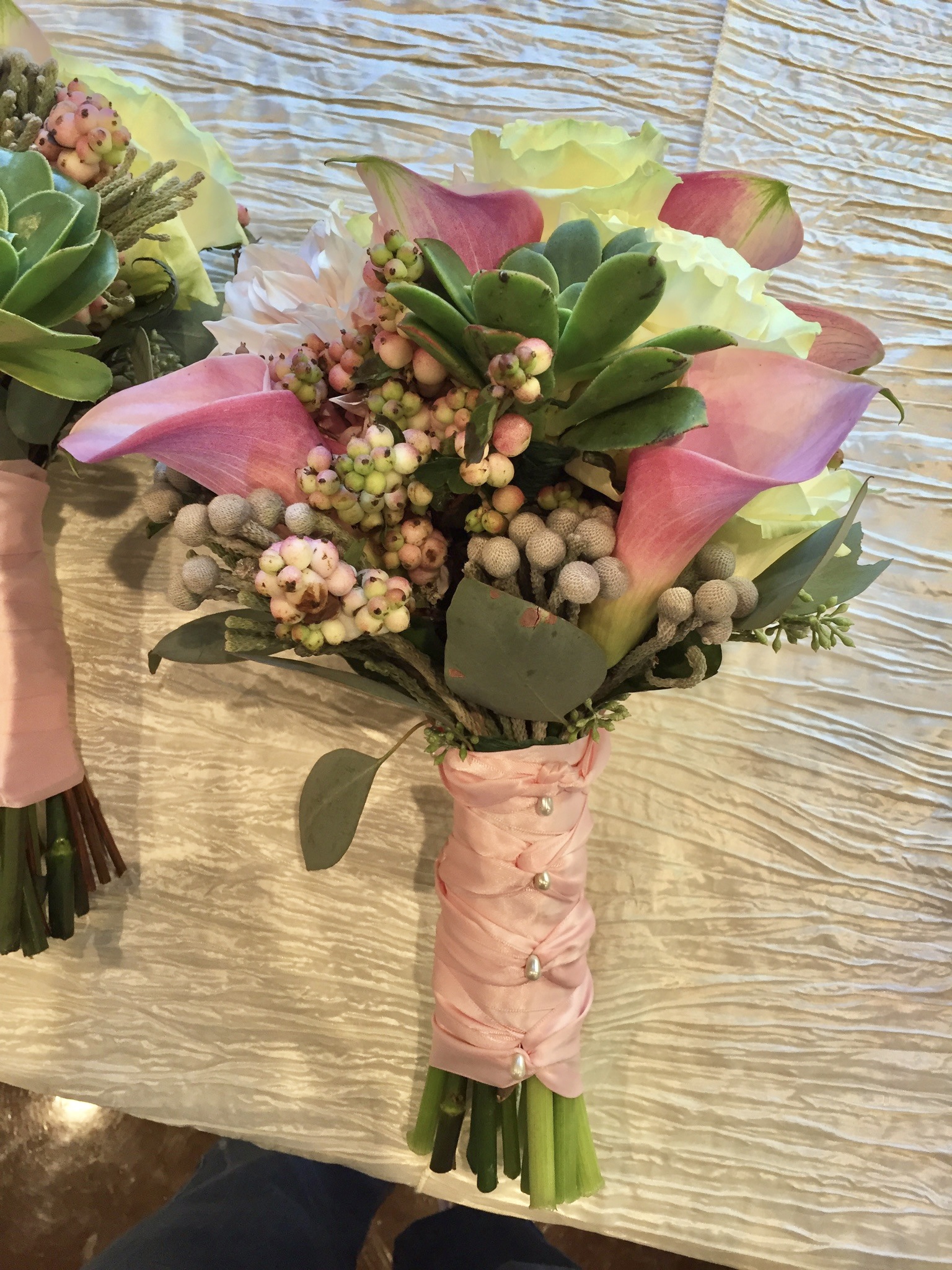 A close up of two bouquets on top of a table.