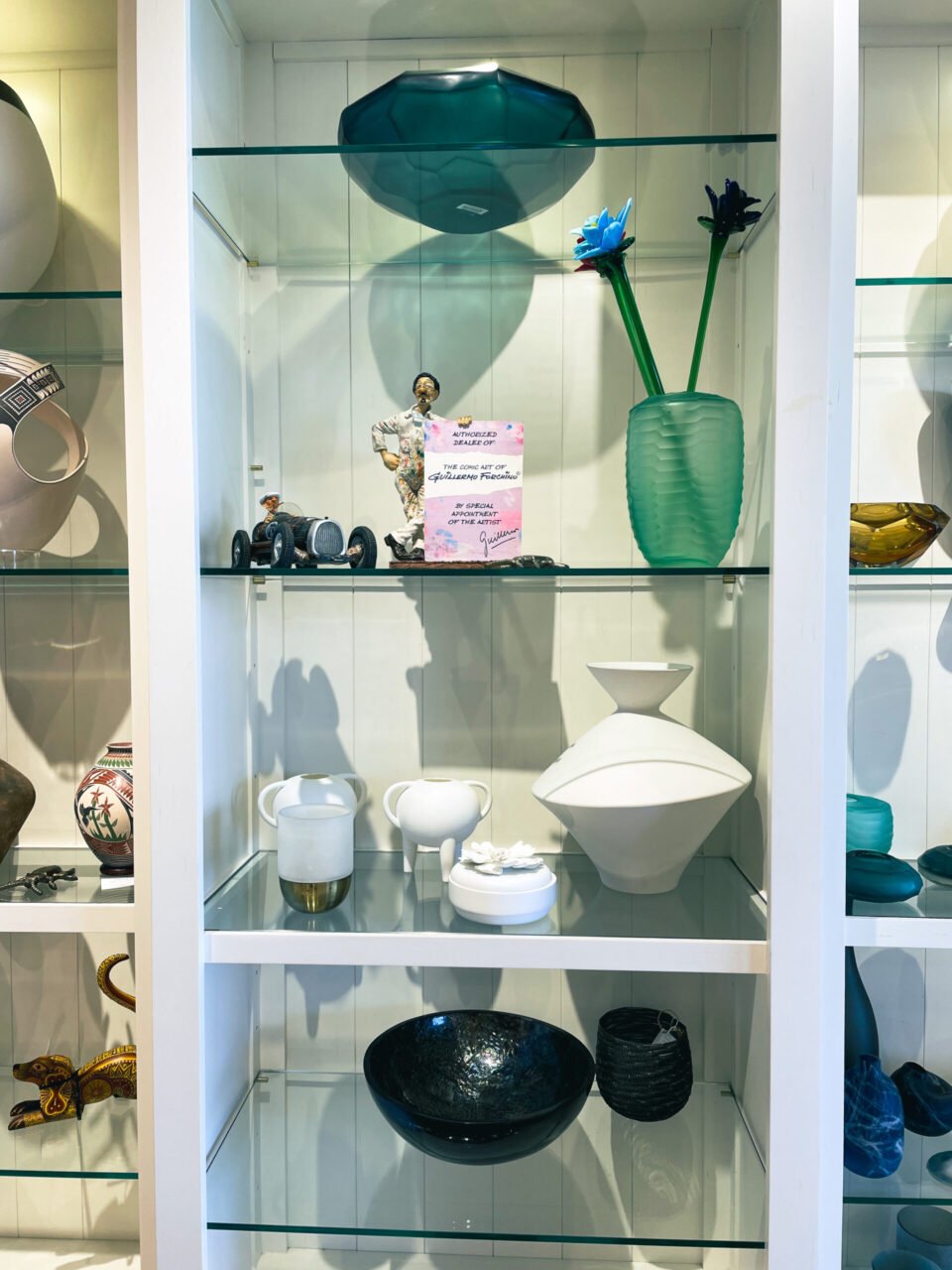 A display case with many different vases and bowls.