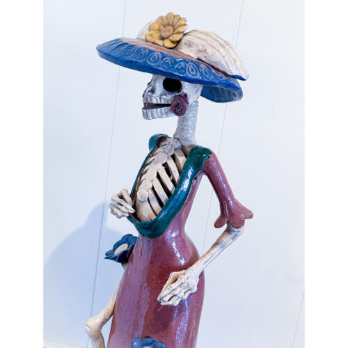 A skeleton wearing a hat and dress